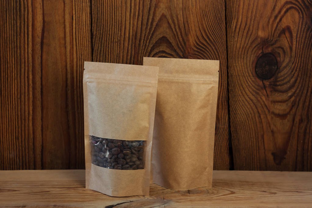 食品独立站设计案例 序藏「储物罐货架」版式封面：木桌上牛皮纸自立袋装的深烘咖啡豆